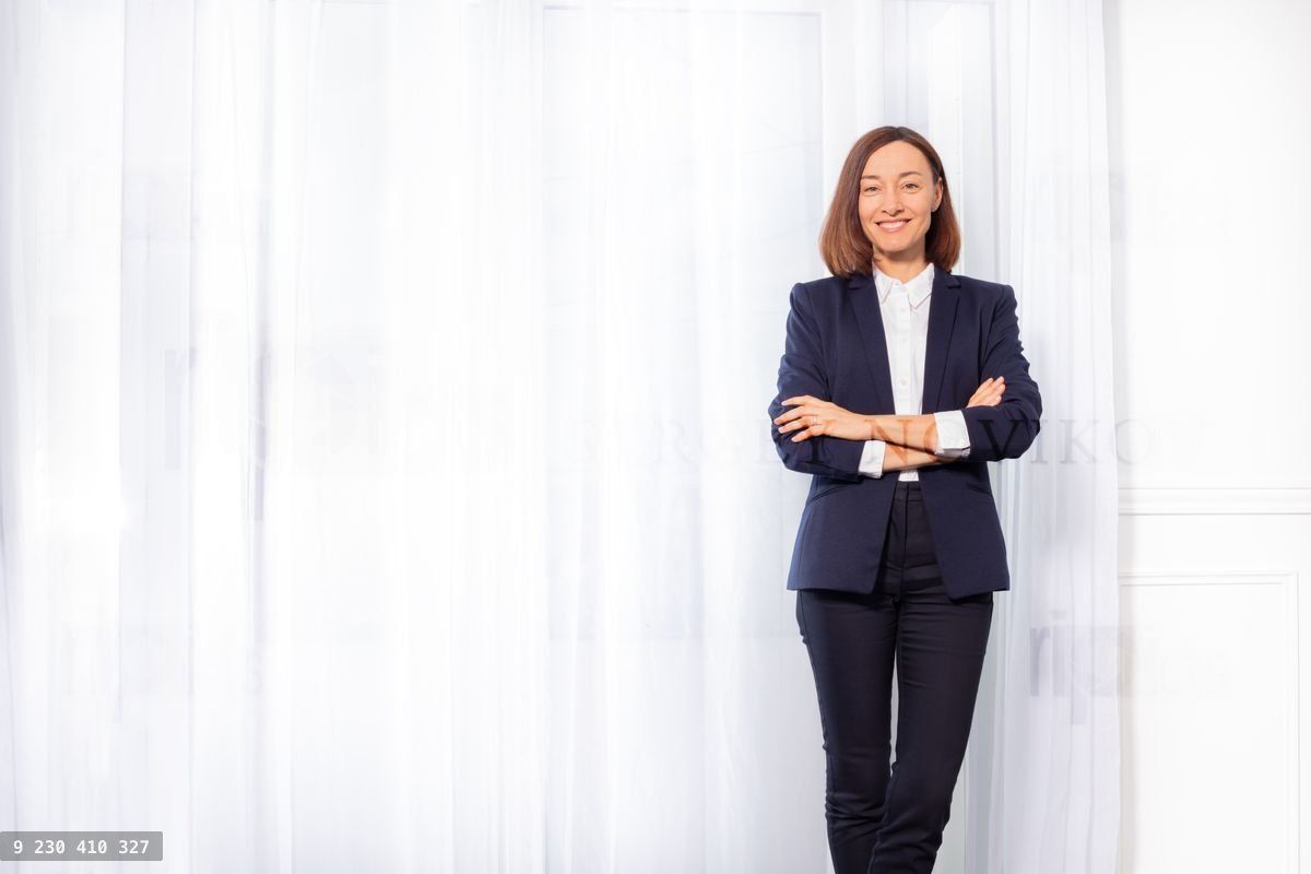 Woman in business suit standing with arms crossed