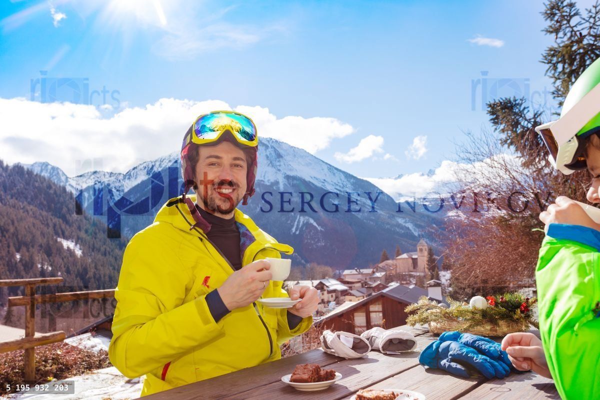 Young happy man in ski outfit on lunch break