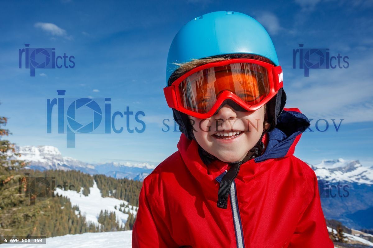 Youngster boy in a red jacket happy to do winter activity