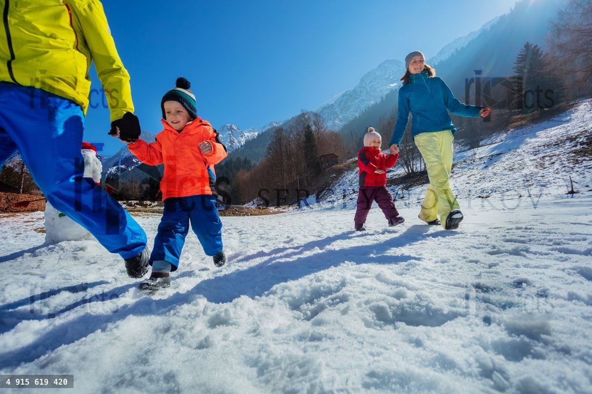 Parents run with small kid in mountains enjoy winter vacations