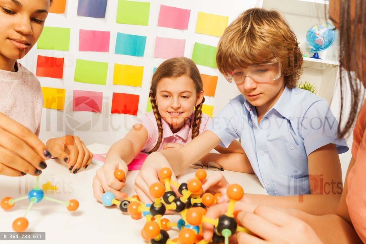 Young boy and girls assembling molecule model