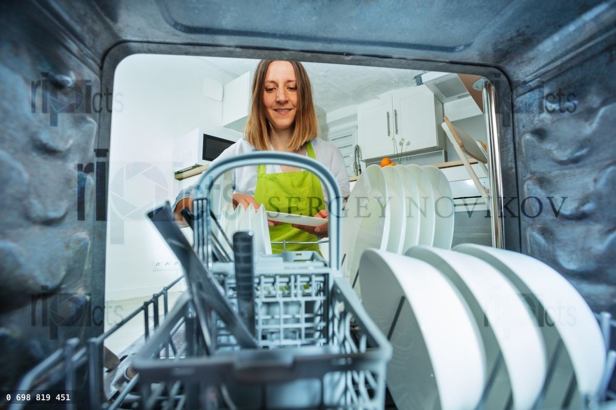 Woman take plates out of dishwashing machine