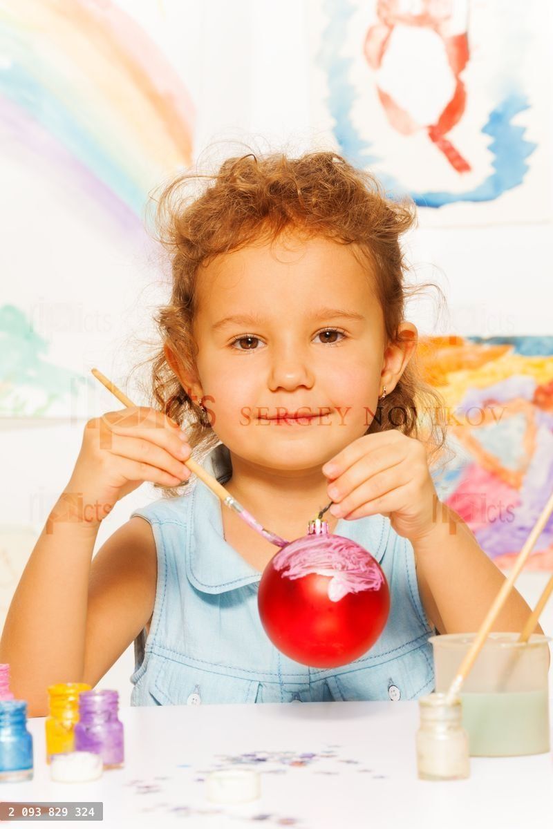 Girl coloring New Year ball for Christmas tree