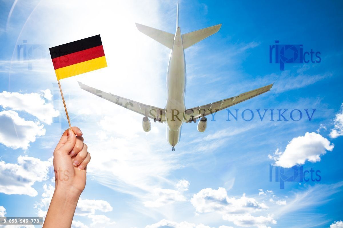 German flag against airplane flying through sky