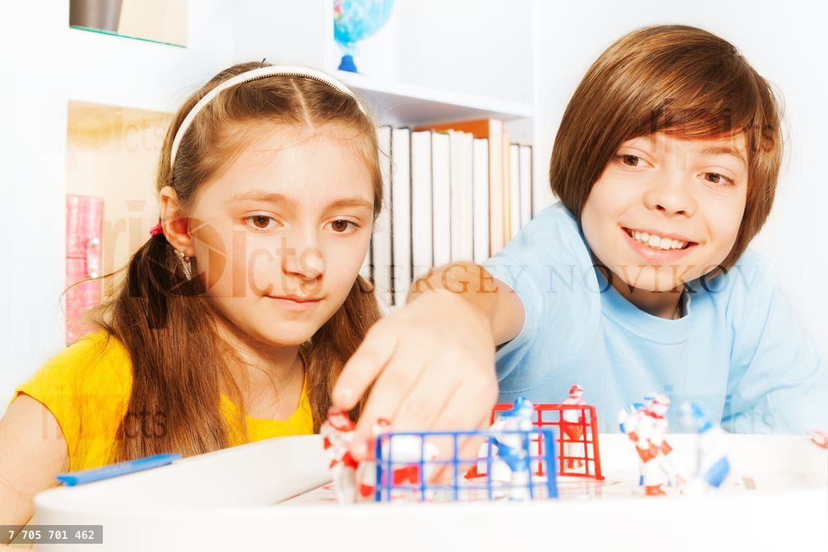 Boy and girl playing ice hockey table board game