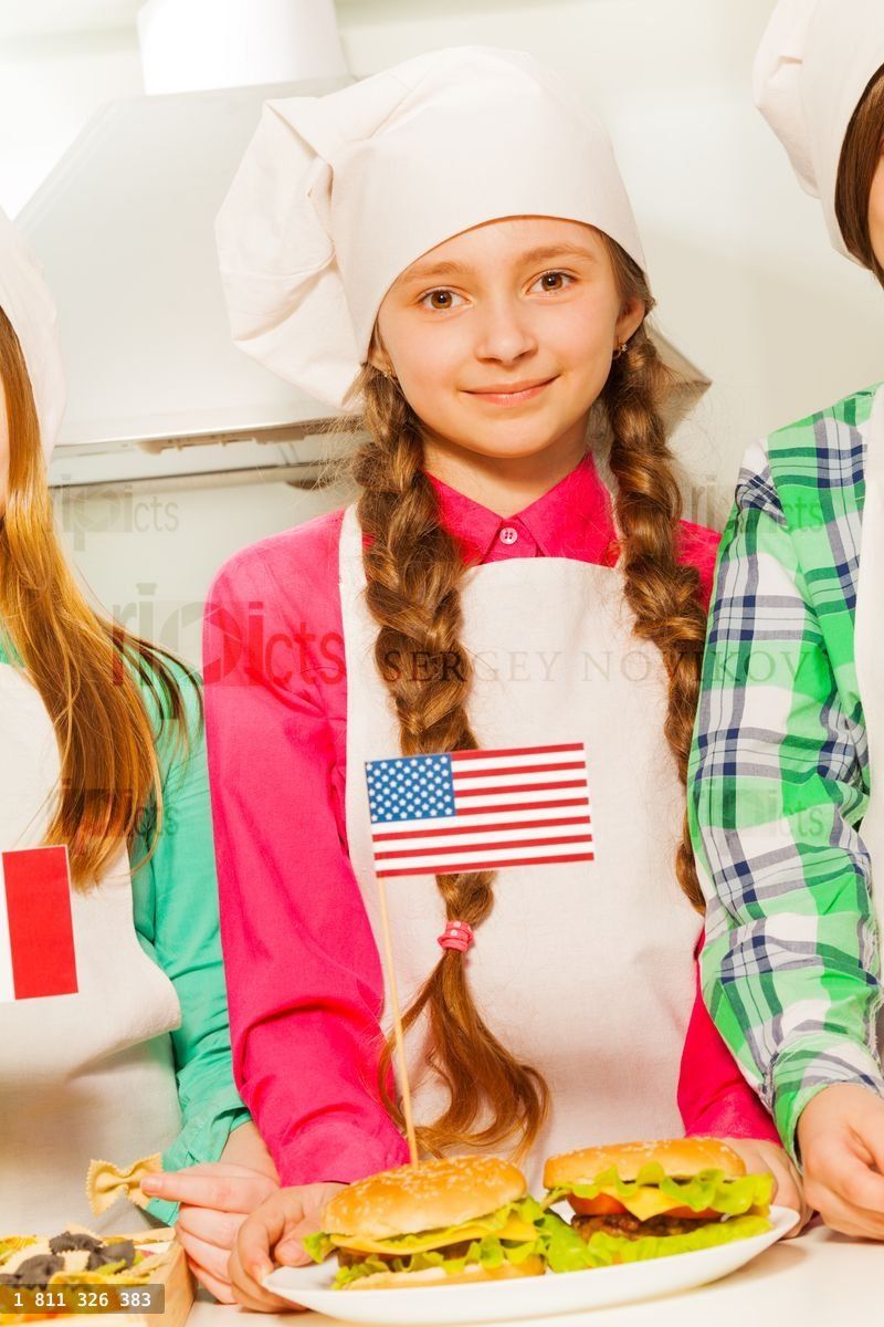 Beautiful young cook with hamburgers on the plate