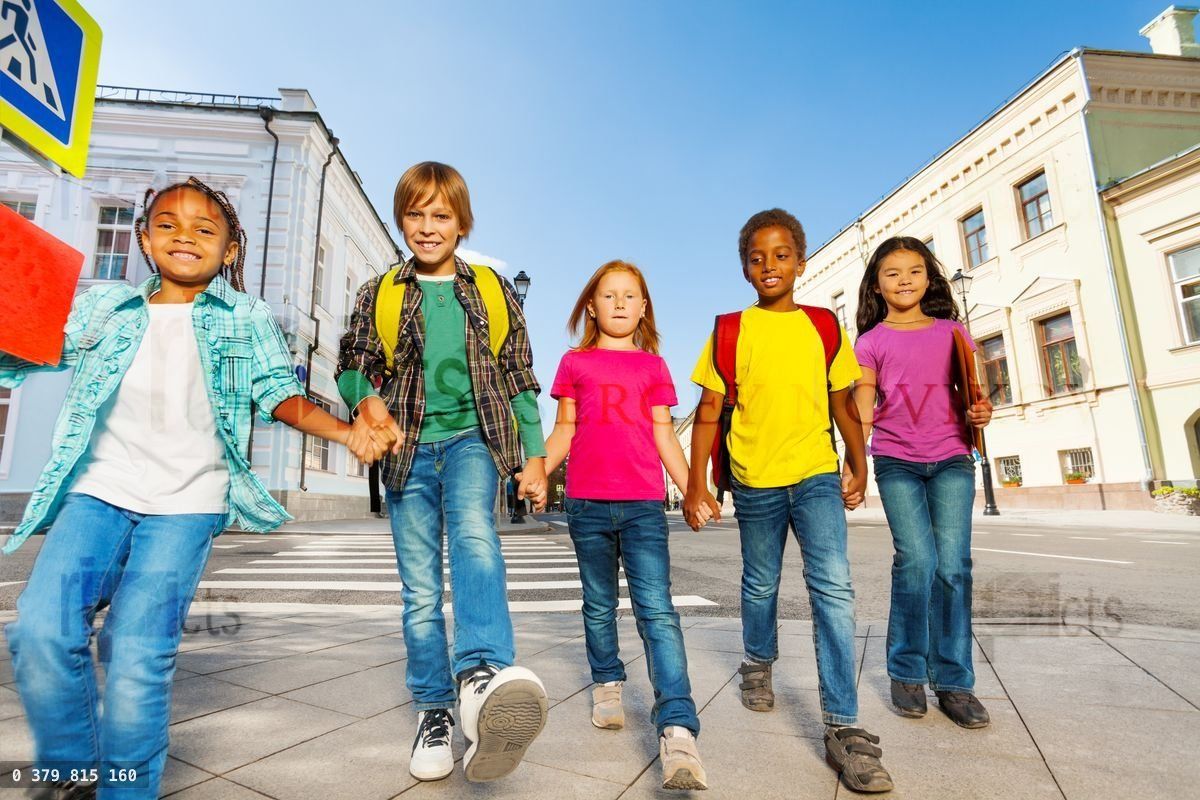 International children wear bags and walk in row