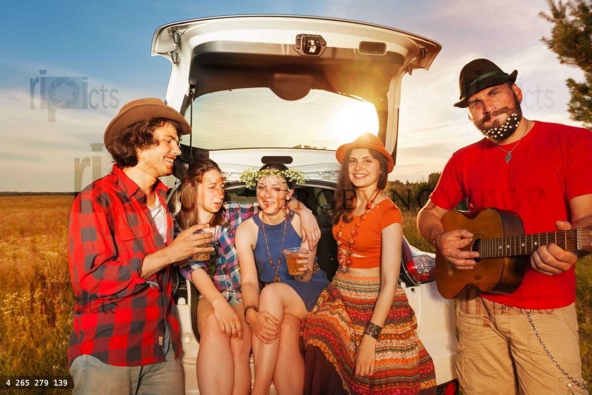 Friends drinking and playing guitar after car trip