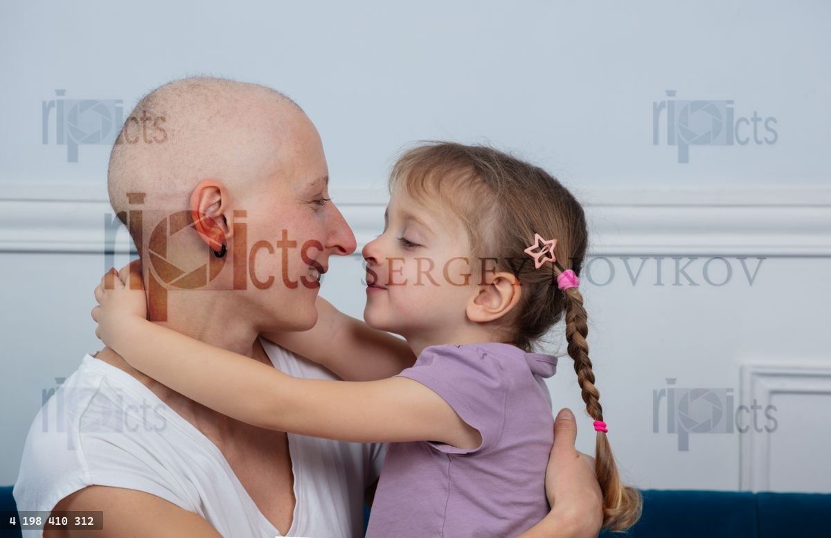 Woman fighting cancer receive supporting hug from her daughter