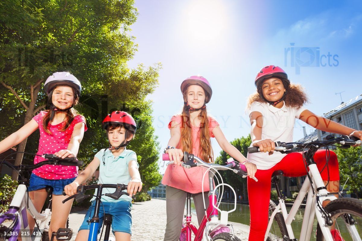 Happy bike riders standing together at summer park