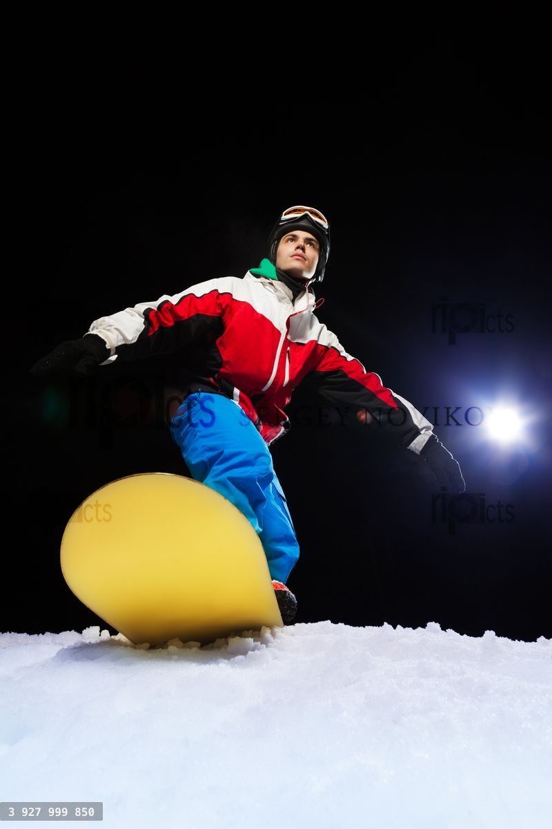 Young snowboarder ready to slide at night