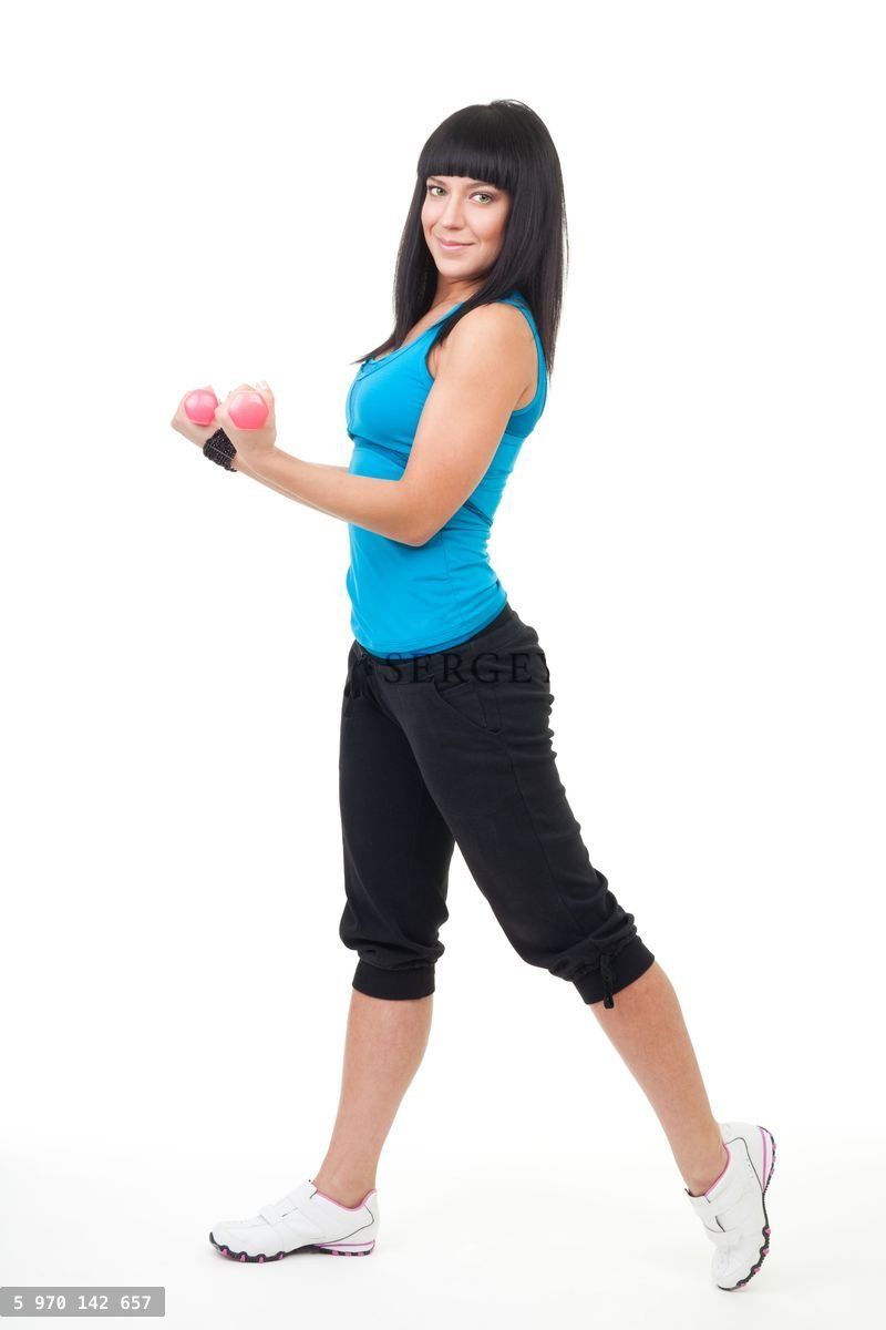 Young positive woman holing dumbbells
