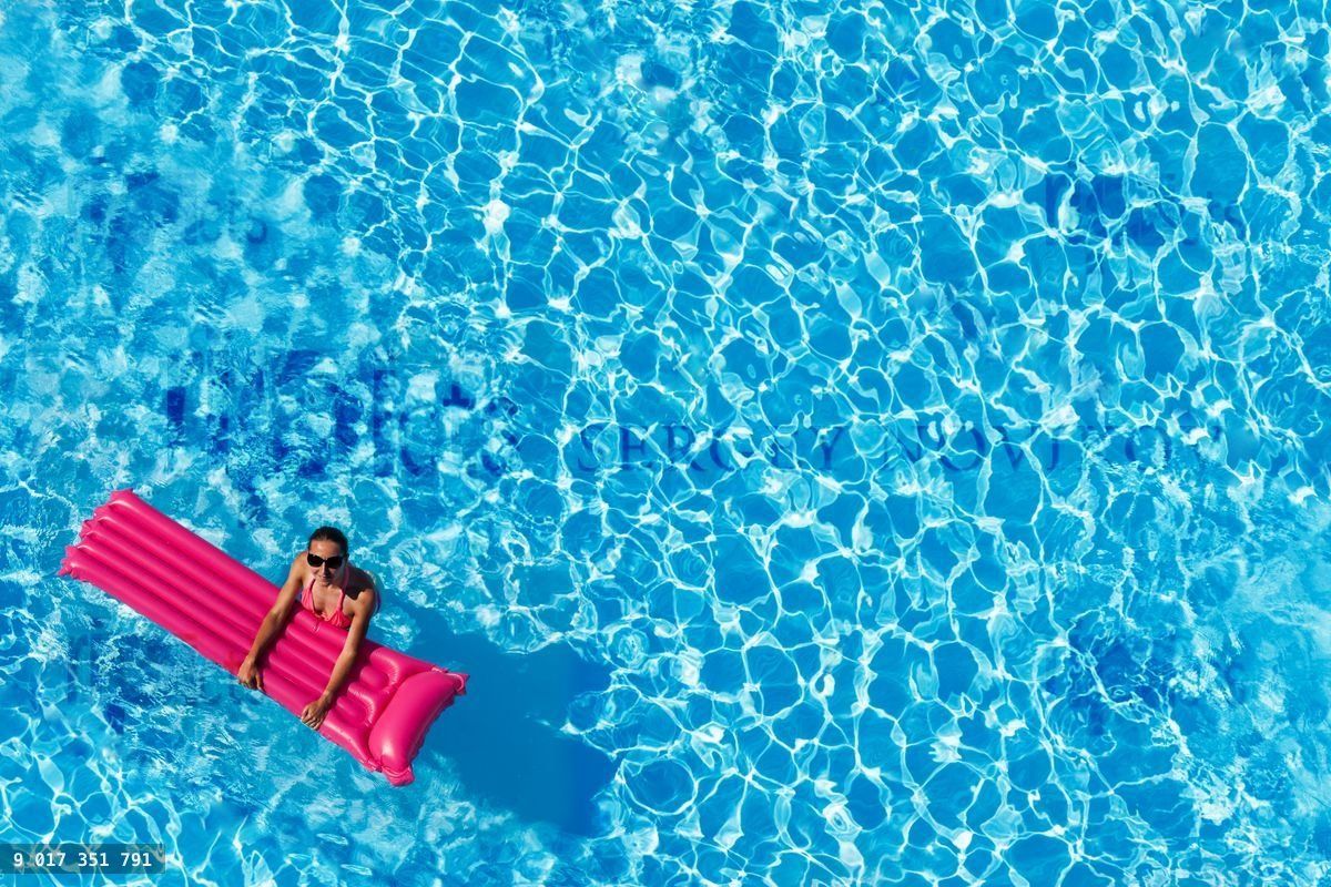 Woman swimming with inflatable mattress in pool