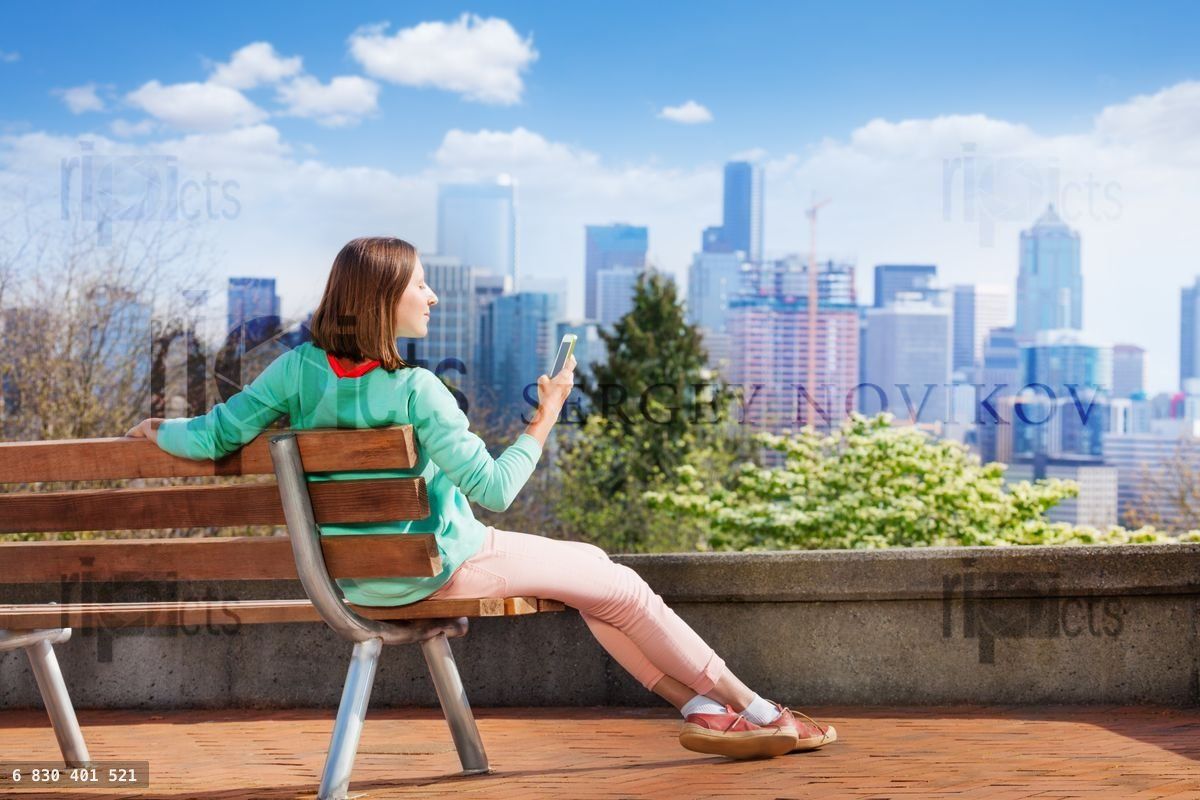 Young woman with cellphone and Seattle downtown