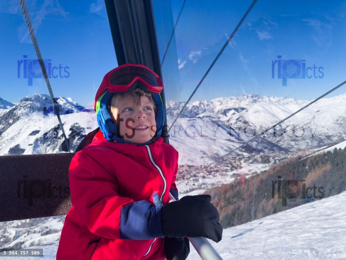Young skier smile in gondola with mountain views on background