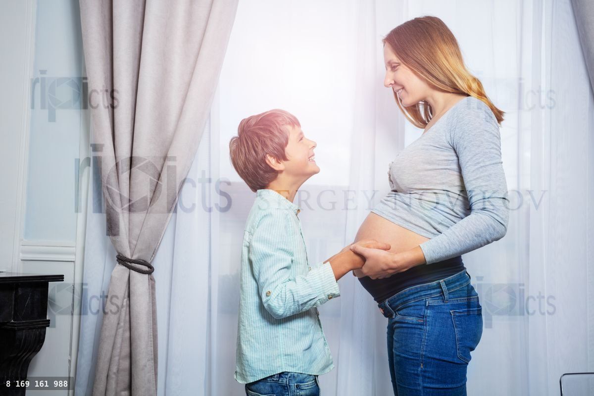 Woman with son boy holding hands touching tummy