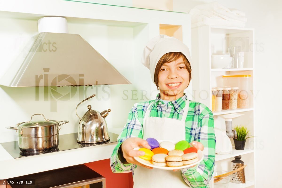Young baker with plate of colored macaroons