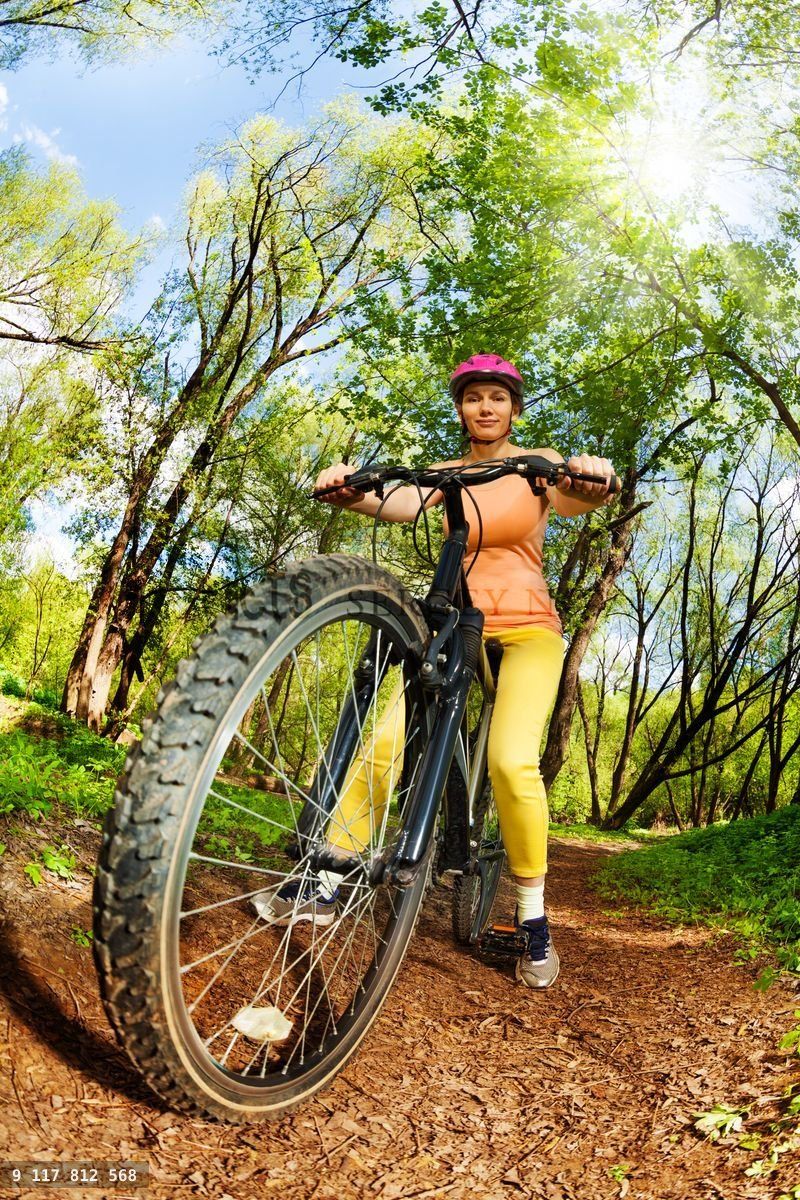 Woman riding a mountain bike on forest trail