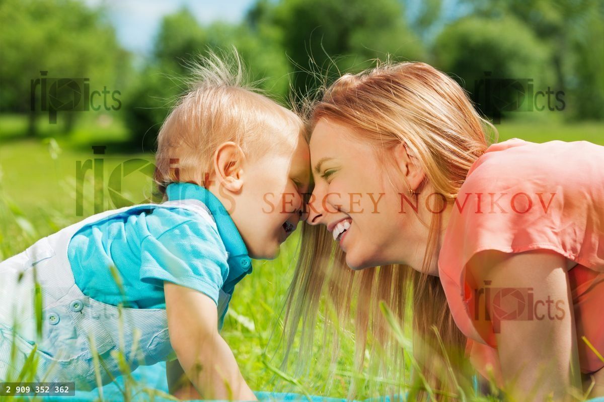 Smiling mother and her child in the green field