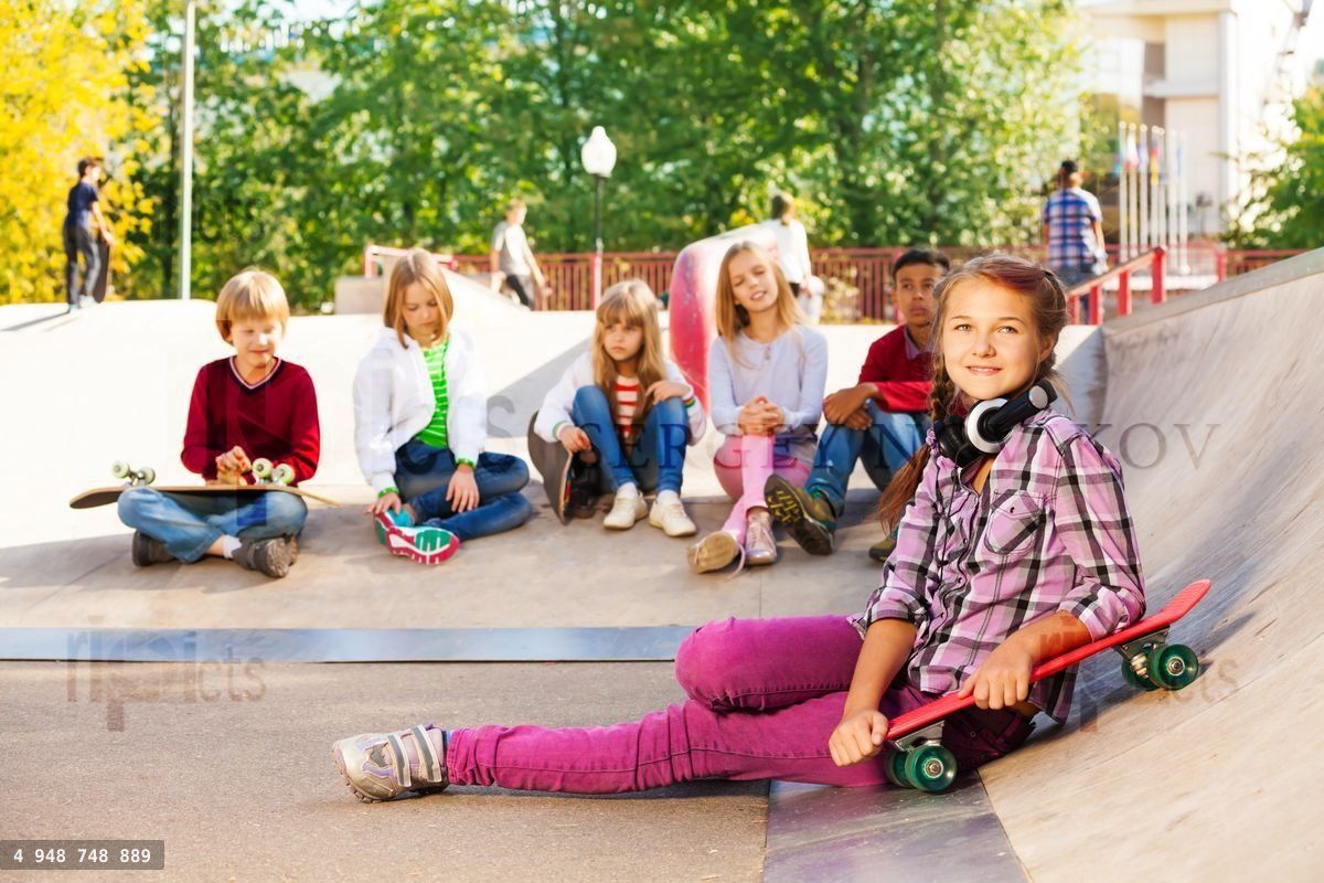 Girl with headphones holds skateboard and mates