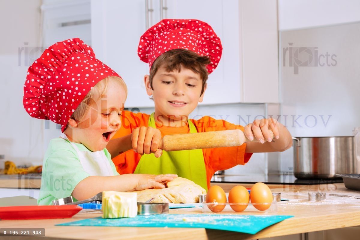Két gyerek szakácssapkában főz, süt sütit