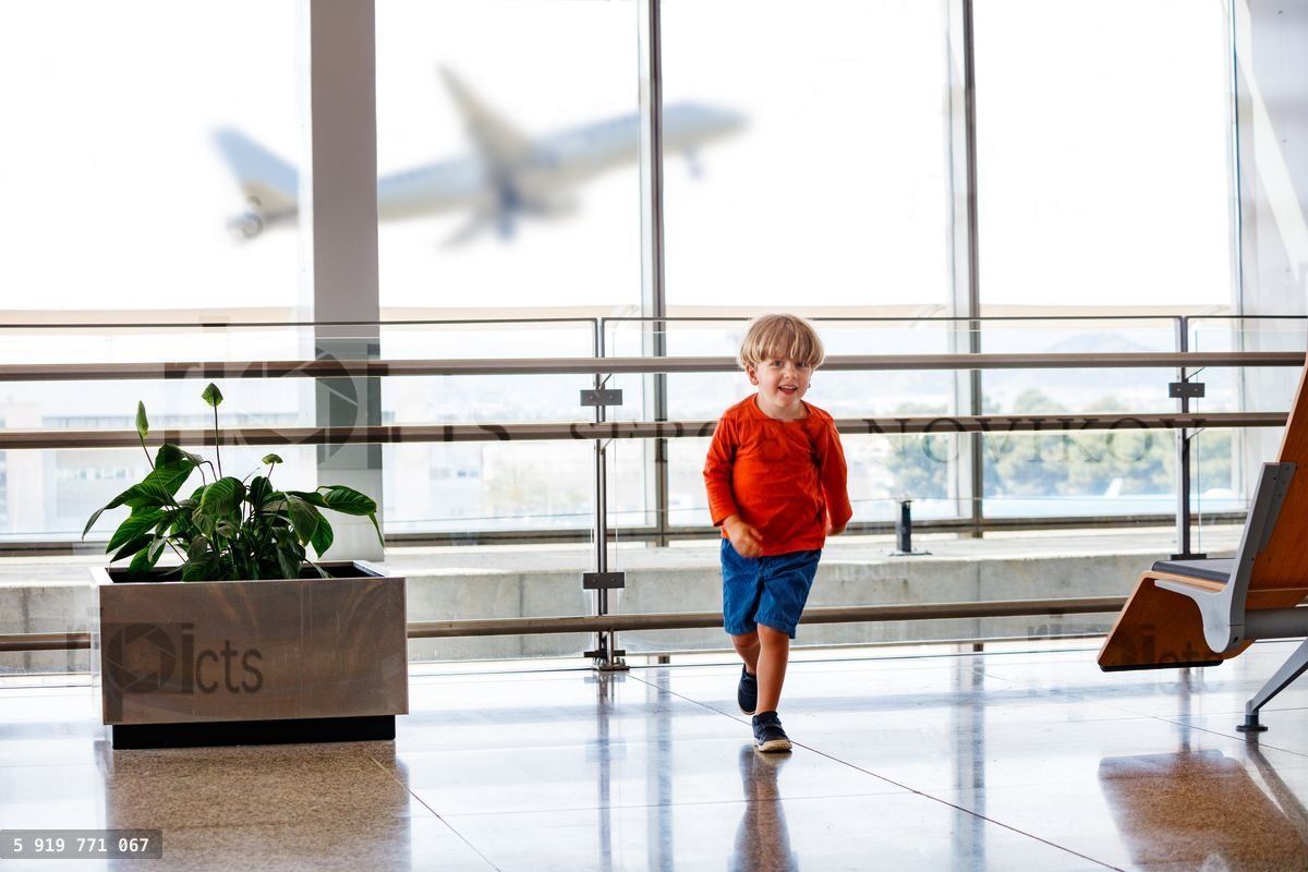 Young child play as plane take off from an airport