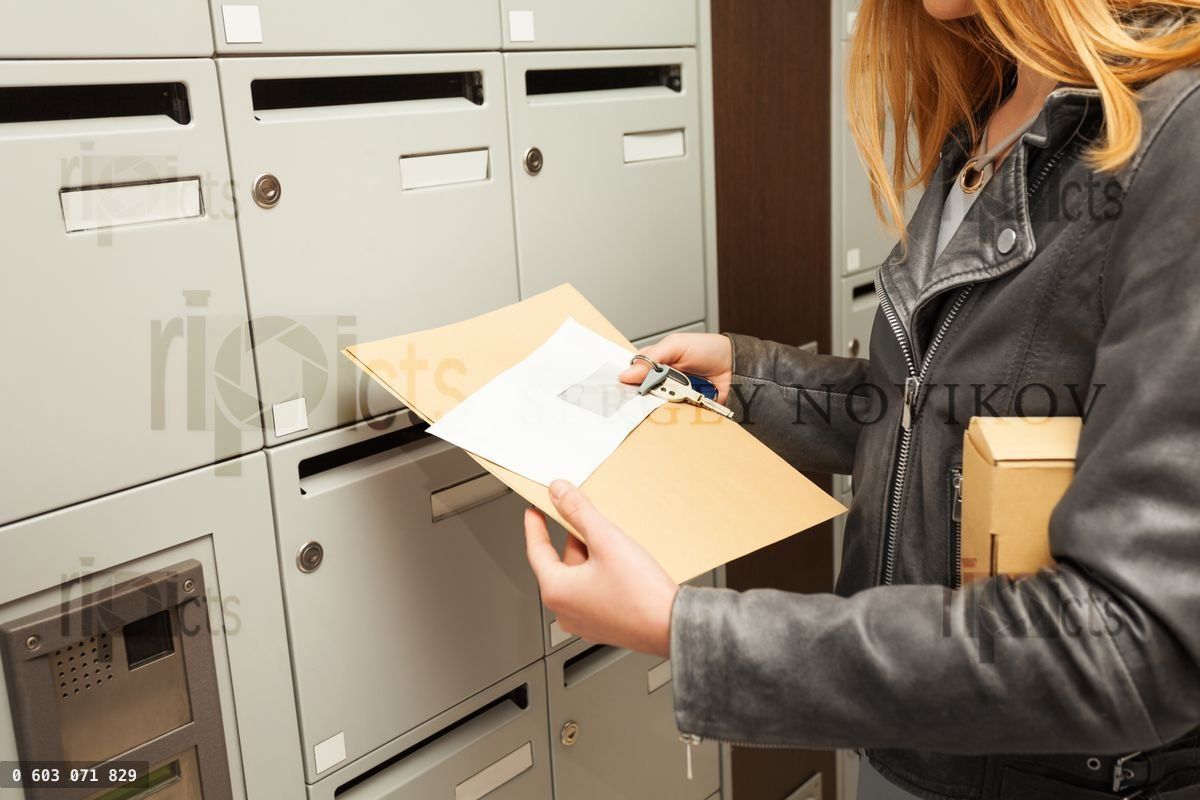 Woman's hands holding blanked envelopes and box