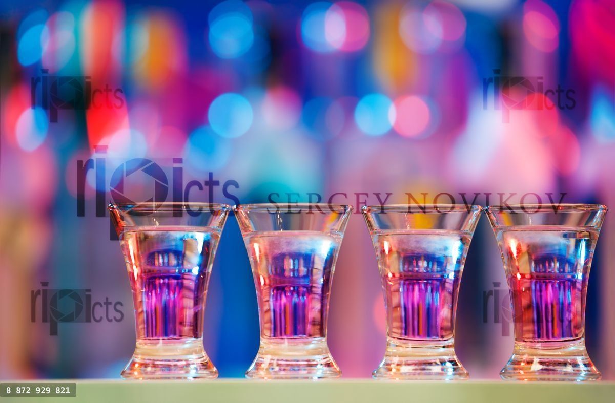 Burning drinks in shot glasses on a bar counter