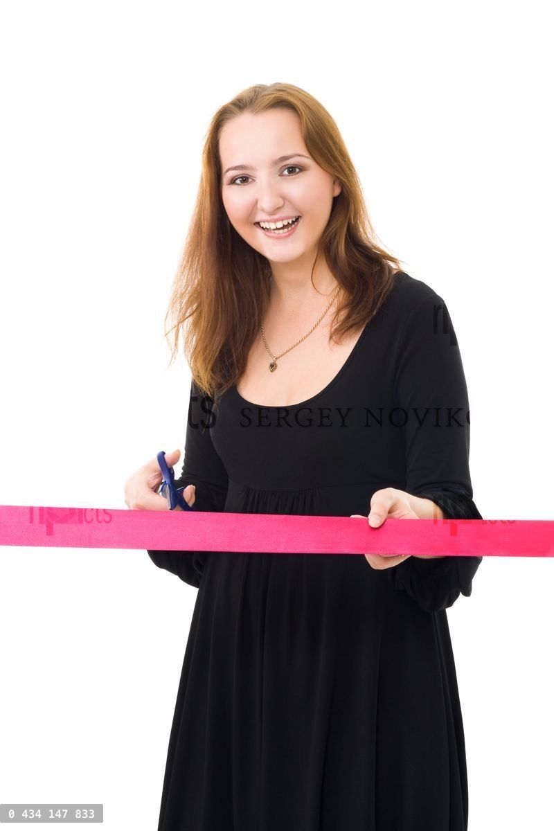 Woman cutting a red ribbon