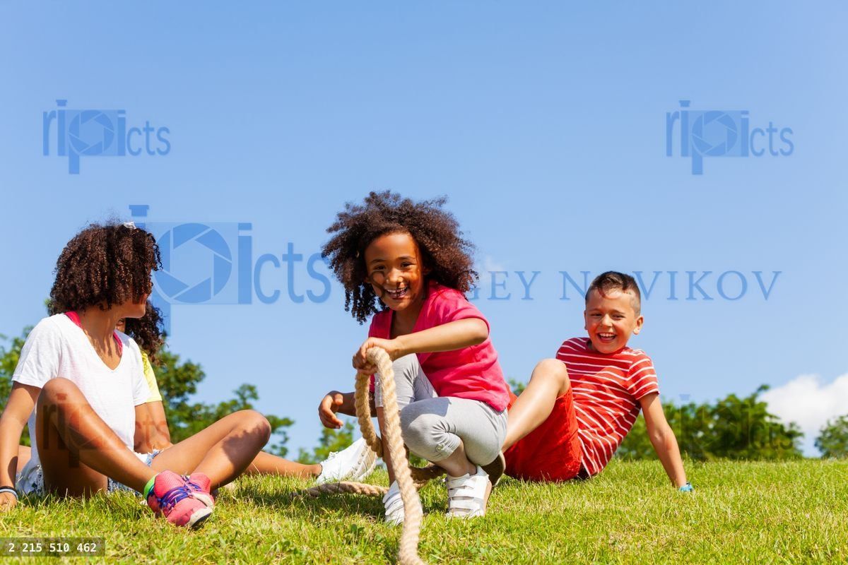 Group of kids fall pulling rope competition game