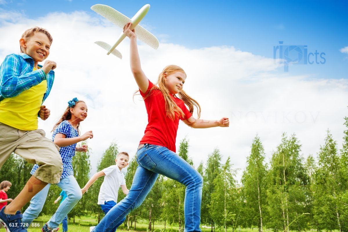 View from below of girl holding big airplane toy