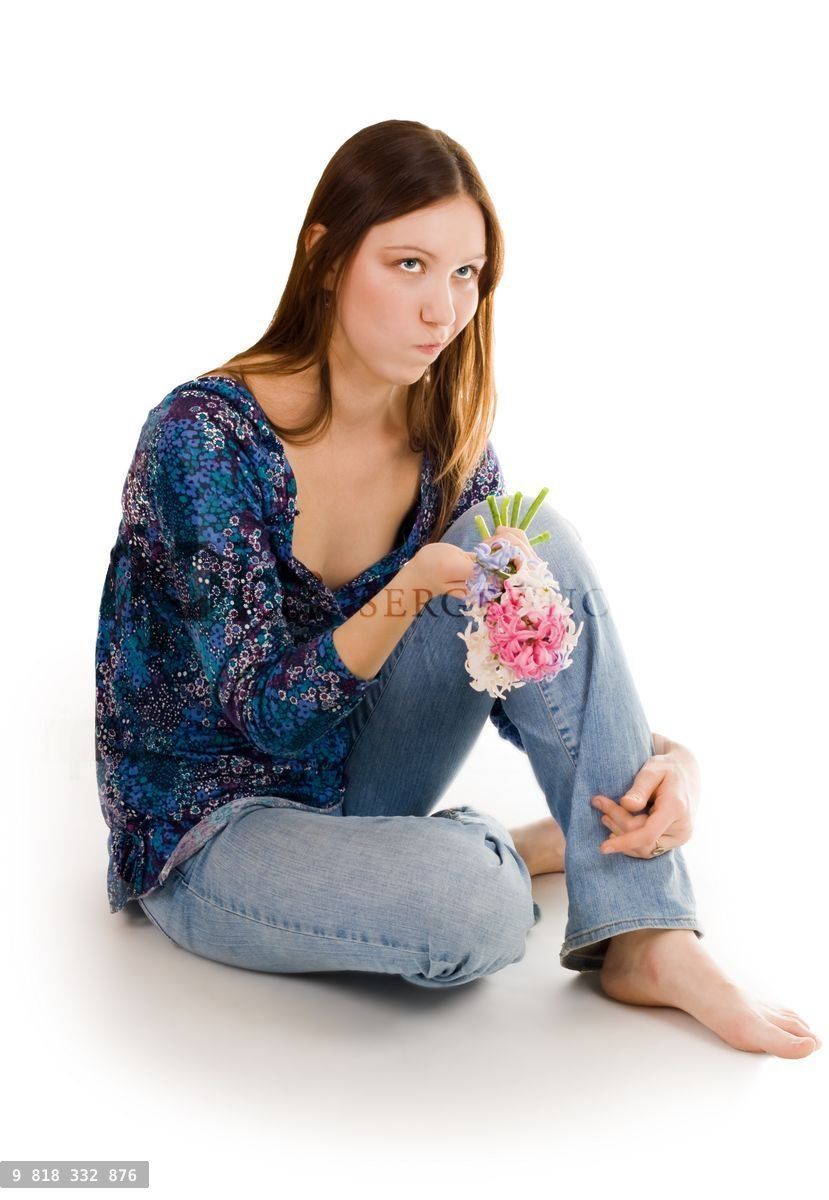 Woman depressed siting on the flor with flowers in hand