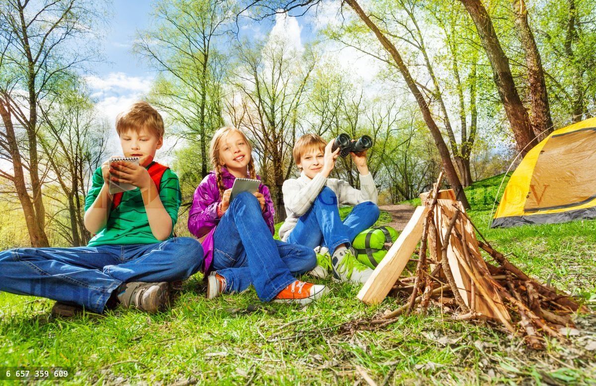 Trois enfants se reposant près du feu de joie en bois