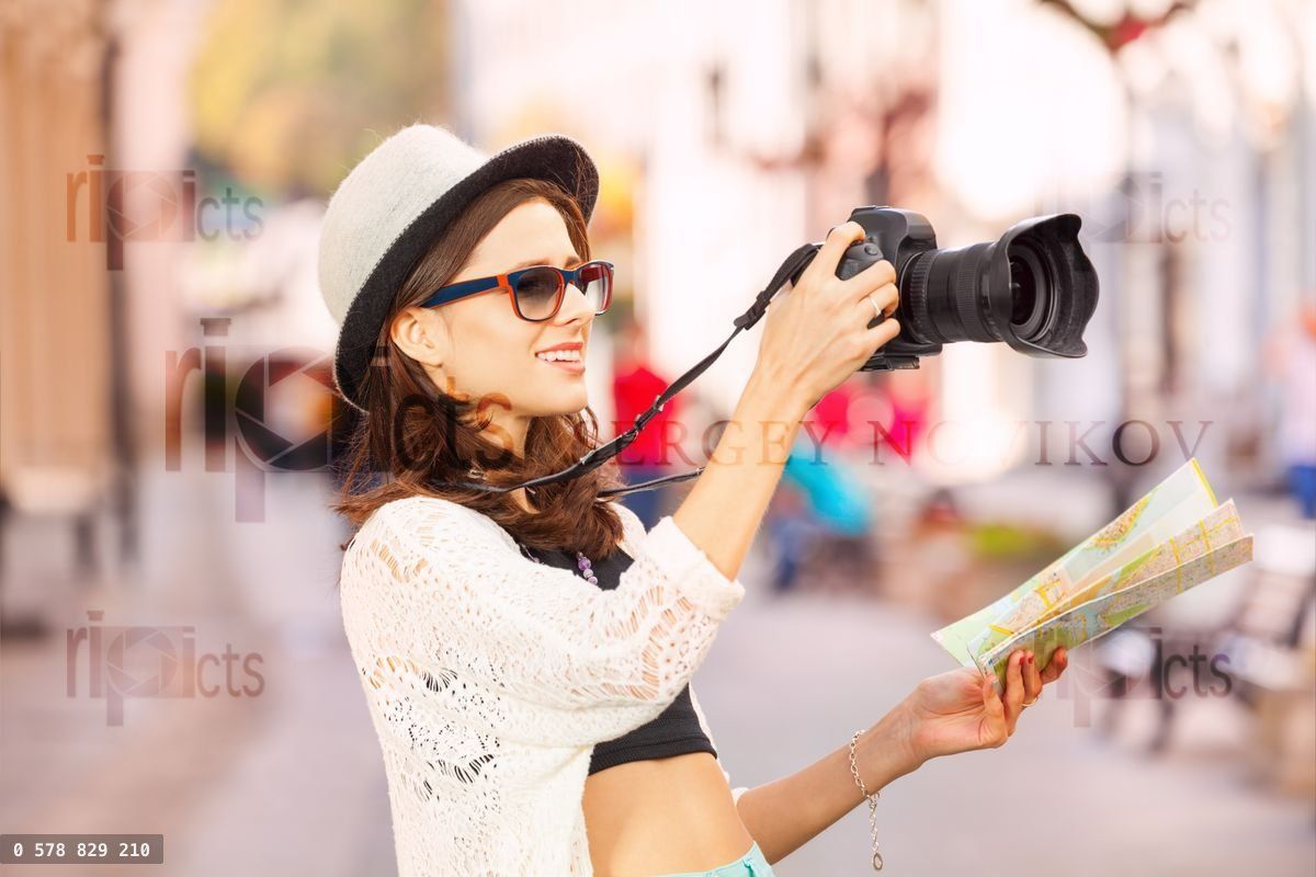 Young woman wearing sunglasses shoots with camera