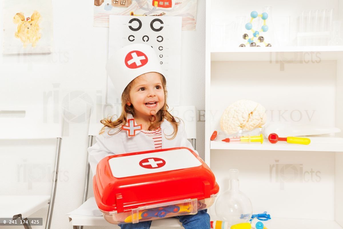 Girl dressed like doctor with toy first aid chest