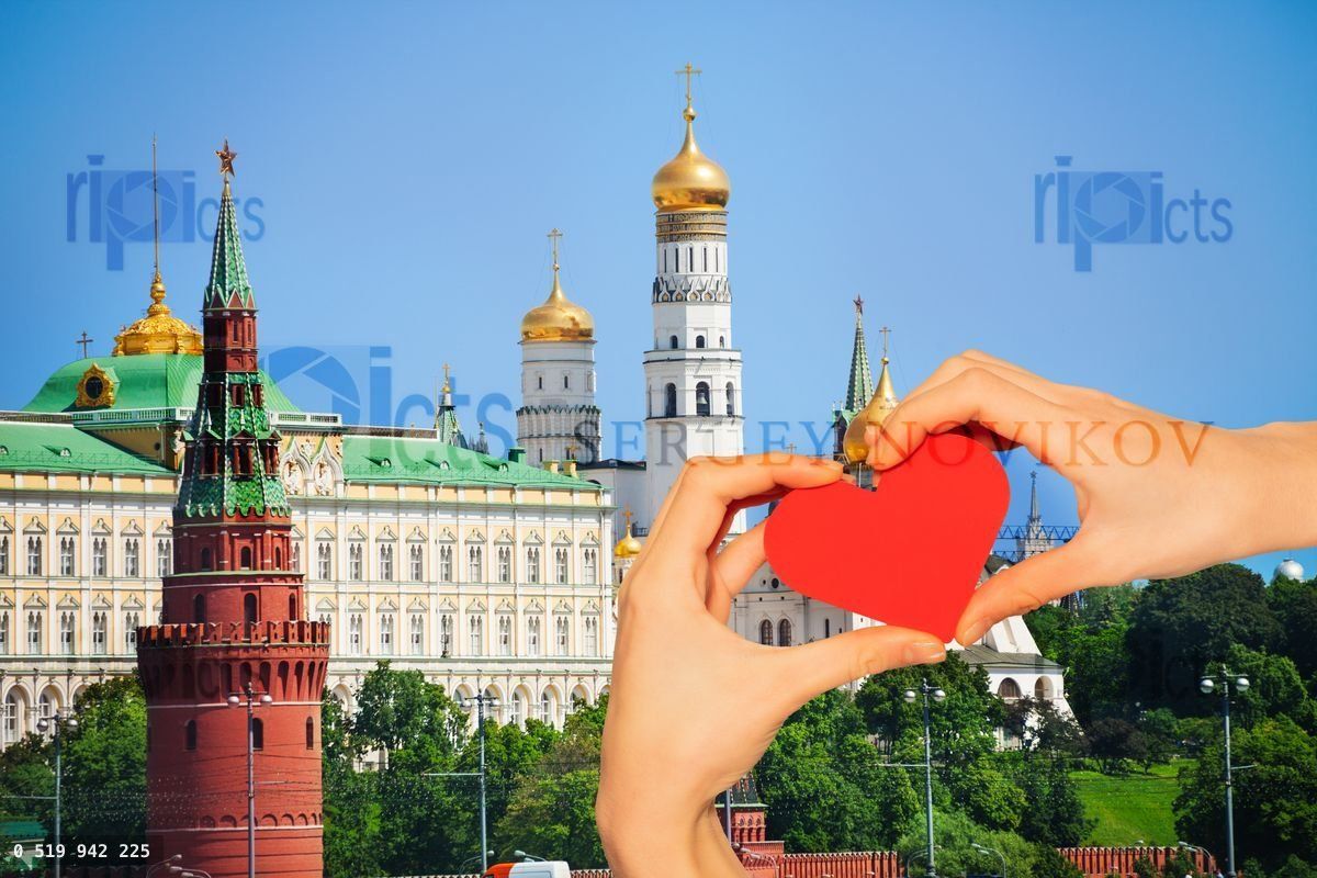 Hand hold red heart over Moscow Kremlin churches