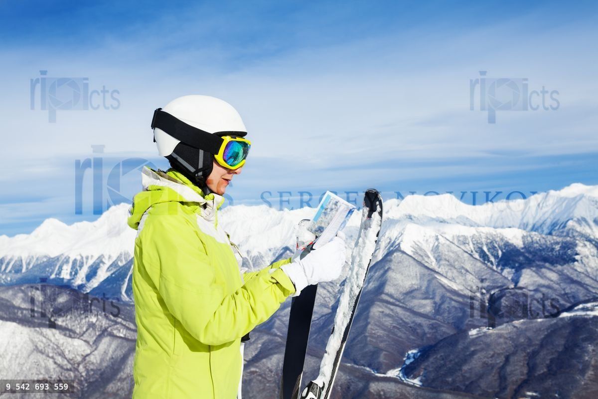 Woman with map of ski resort over mountains