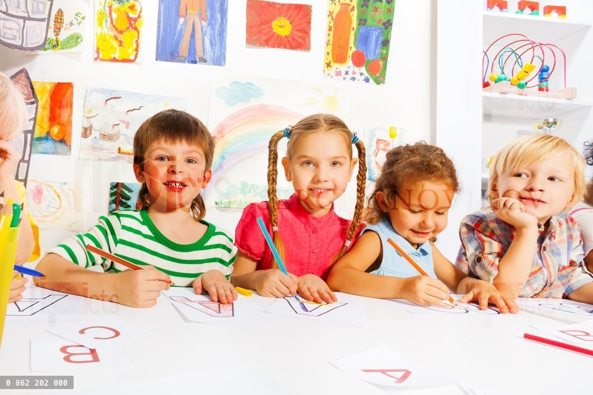 Boys and girls drawing letters in writing lesson