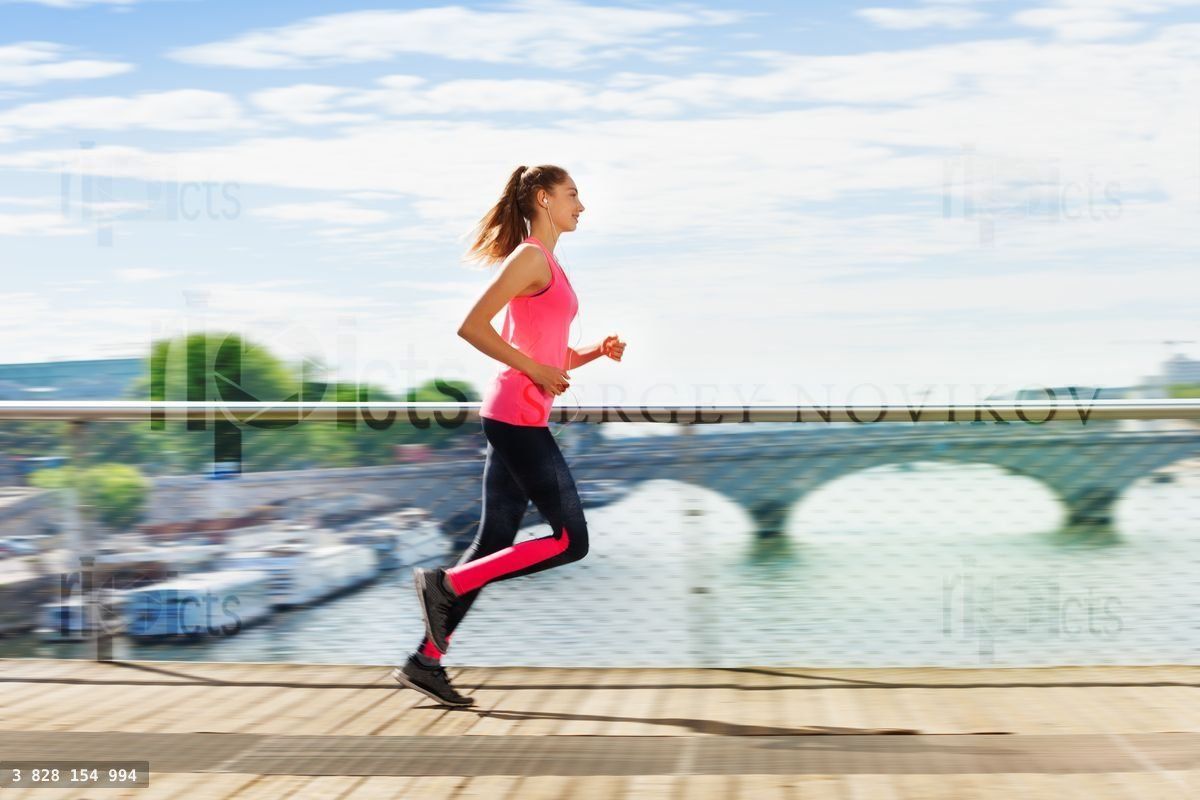 Woman running across bridge during cardio exercise