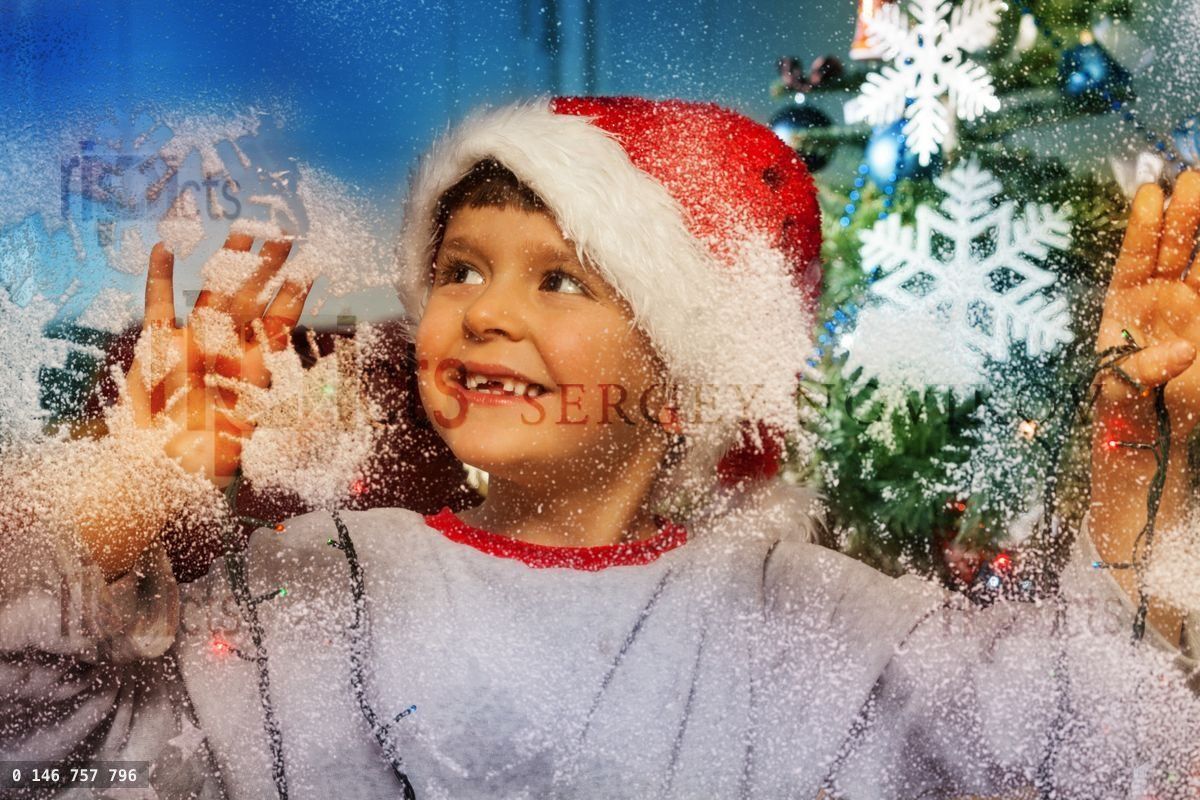 Boy behind decorate window before Christmas