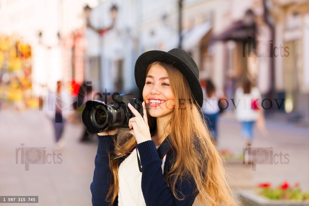 Beautiful young woman shooting with camera