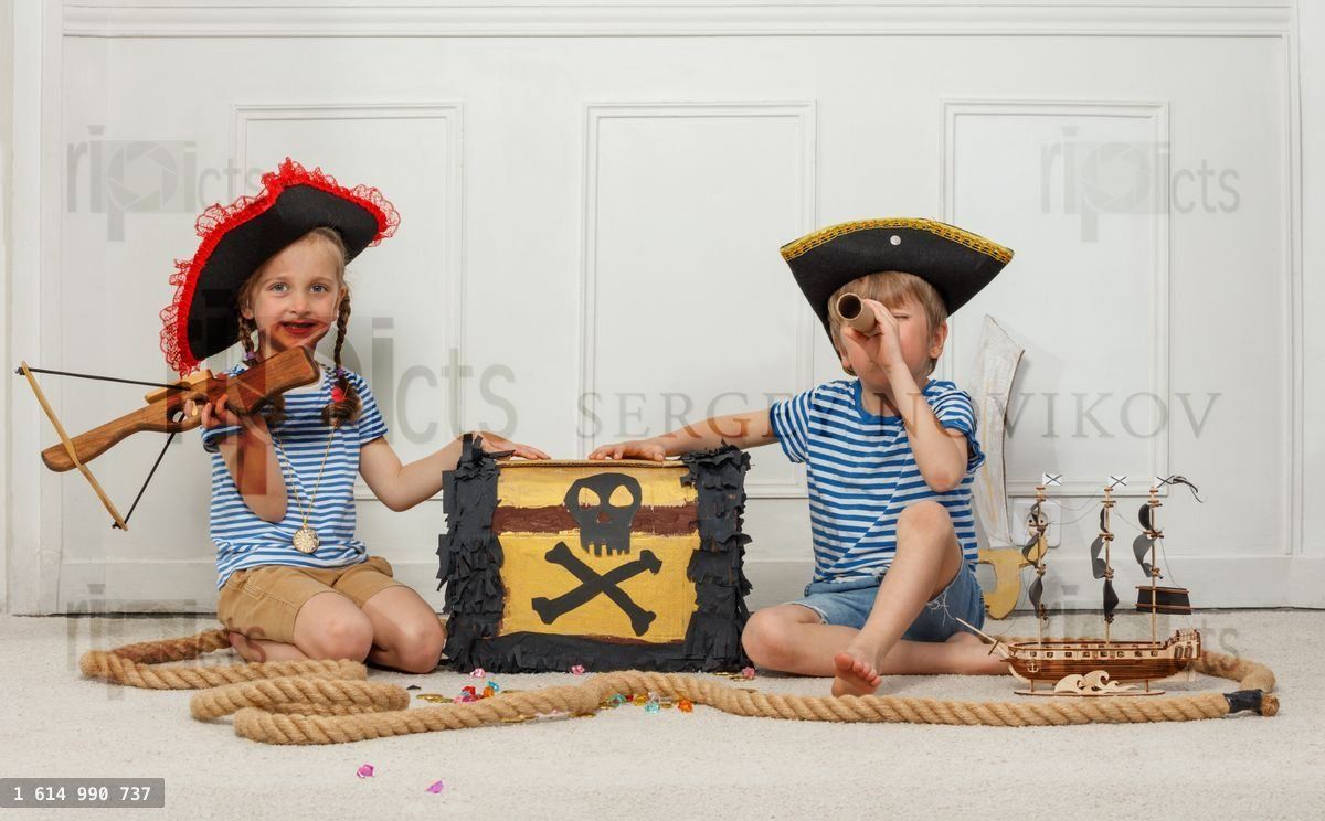 Young pirates with a treasure chest and telescope in playtime