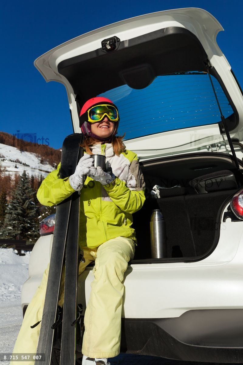 Young woman having rest after skiing, drinking tea