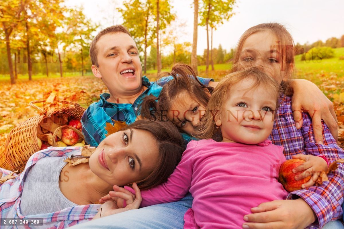 Close up of the family laying in autumn leaves