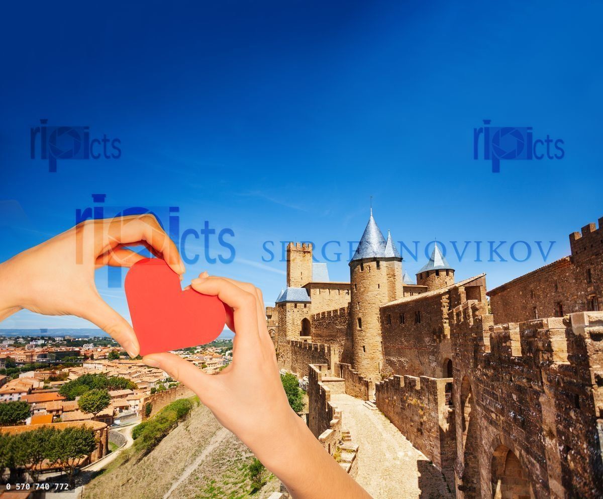Hand hold red heart over Carcassonne city walls