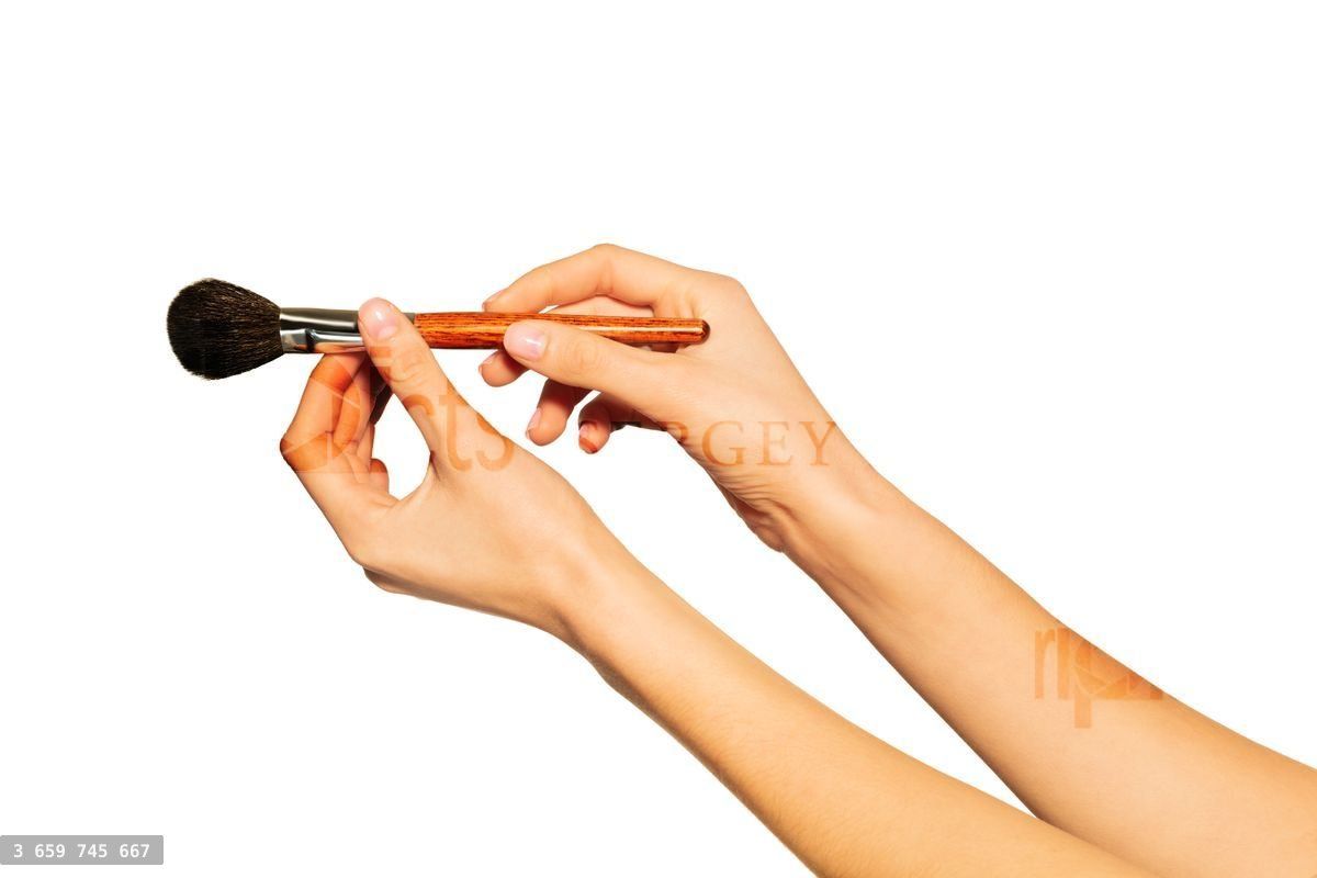 Woman's hands holding makeup powder brush on white