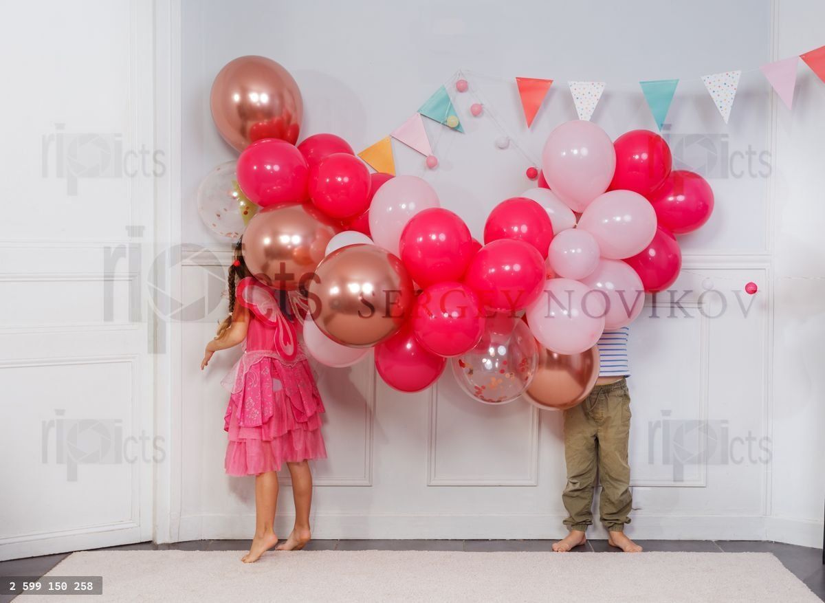 Funny kids hide heads in butch of bday balloons, concept image