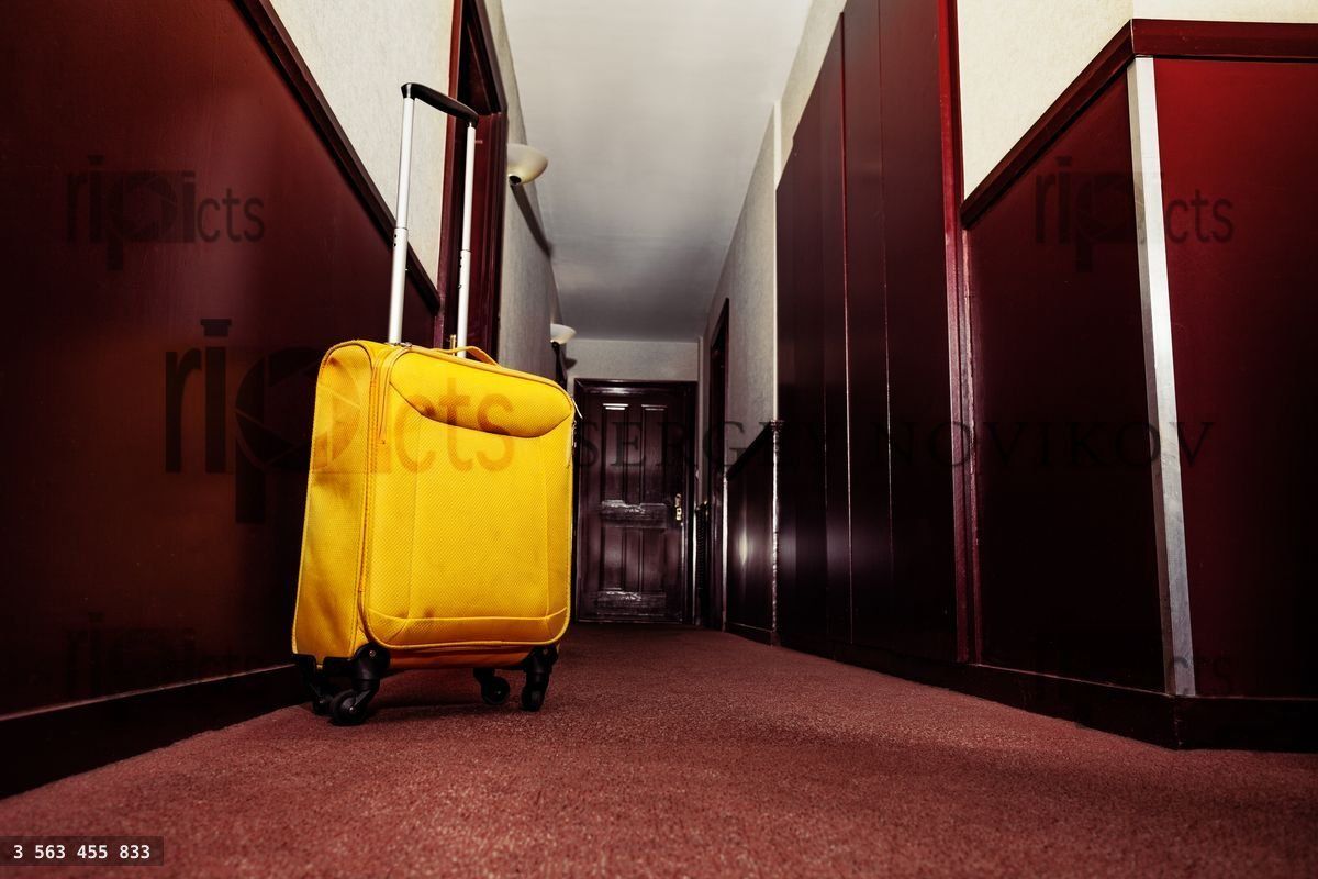 Yellow suitcase in hall of hotel corridor concept