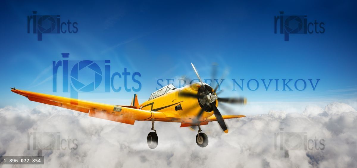 Yellow plane flying in the sky between clouds