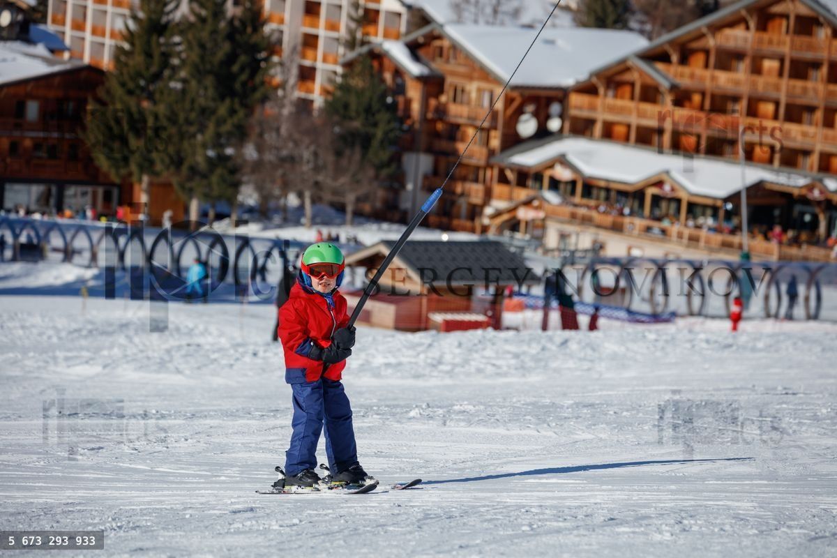 Child ski in colorful attire among breathtaking snowy mountains